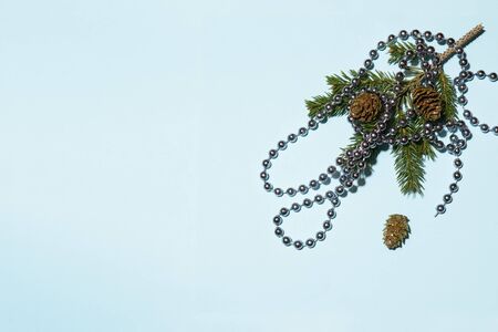 Christmas beads on spruce branches on a blue background.の写真素材