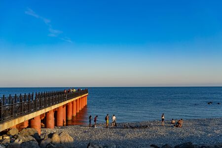 Sochi, Russia-June 09, 2018: Seascape with beach and pier. People rest on the rocky shore.のeditorial素材
