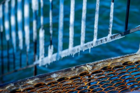 Metal construction in ice on a blurred background.の写真素材