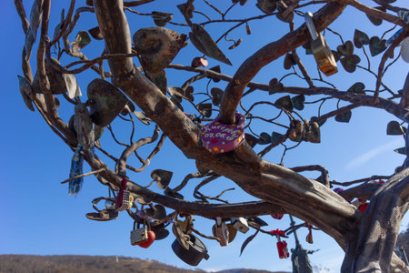 Petropavlovsk-Kamchatsky, Russia-October 8, 2019: Metal tree of lovers on a background of blue sky.