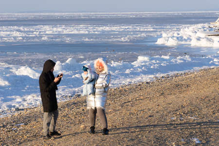 Vladivostok, Russia-January 18, 2019: a Young couple with a child on the shore of the Amur Bayのeditorial素材