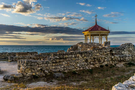 Sunset over the sea in the ancient Chersonesos among the ruins and buildingsの写真素材