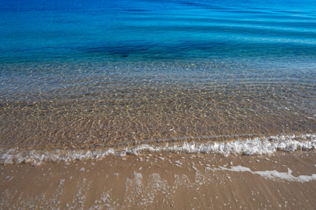 Natural background with water surface and sandy beach.