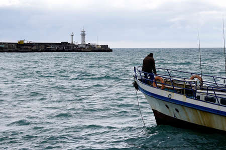 Seascape with a view of the fisherman on the bow of the ship. Yalta, Crimeaのeditorial素材