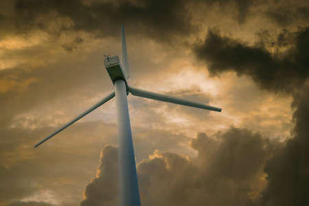 Wind power plant against a sky with white cloudsの写真素材