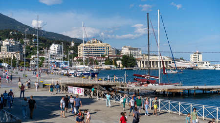 Yalta, Crimea-June 8, 2021: Urban landscape with a view of the embankment. People are walking by the sea.のeditorial素材