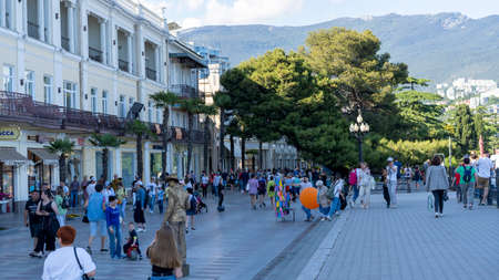 Yalta, Crimea-June 8, 2021: Urban landscape with a view of the embankment. People are walking by the sea.のeditorial素材