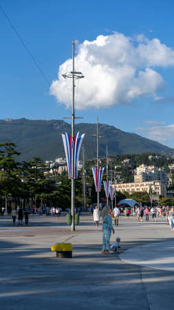 YALTA, Crimea-June 12, 2021: Urban landscape with a view of the embankment. People are walking by the sea.のeditorial素材