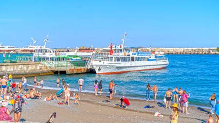 Yalta, Crimea-June 8, 2021: Urban landscape with a view of the embankment. People are walking by the sea.のeditorial素材