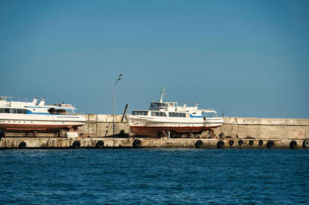 Seascape with a pier in Yalta and old boats in the parking lot.の写真素材