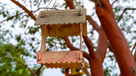 Wooden bird feeders on a blurry background of trees.の写真素材