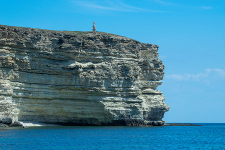 Seascape with a view of a high cliff by the sea.