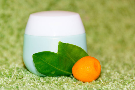 blue jar of cream and Mandarin orange with leavesの写真素材