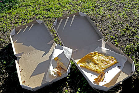 pizza boxes on the ground  opened with pizza piecesの写真素材