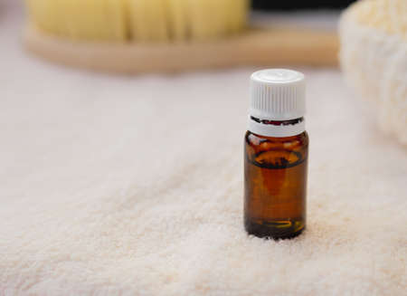 the essential oil in an amber glass bottle, white towel, body brush, copy space, spa procedures products, eco cosmetic,の写真素材