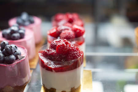 Sweet purple and white smoothie cupcakes display in restaurant. Raw vegan smoothie Blueberry Muffins. Berry Cream Cheese Muffins.の写真素材