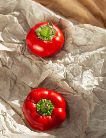Red sweet peppers on crumpled paper. Recycled eco paper background.の写真素材