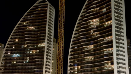 The stunning nighttime skyline showcases beautiful unique architecture along with a towering...