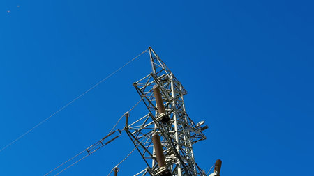 A towering structure for electrical transmission under a vibrant blue sky, showcasing engineering...