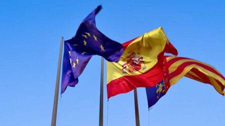 The European Union and Spanish national flags are waving proudly in the wind under a brilliantly...