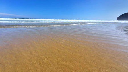 A serene and tranquil beach scene featuring inviting golden shores and gentle waves beneath a bright...
