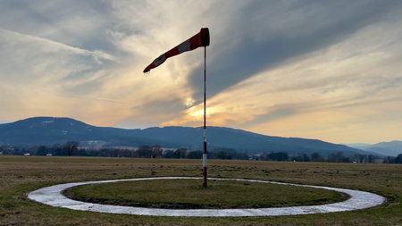 A vibrant windsock stands tall against a picturesque twilight backdrop