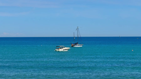 Enjoy tranquil views of boats sailing in pristine turquoise waters under a clear blue sky