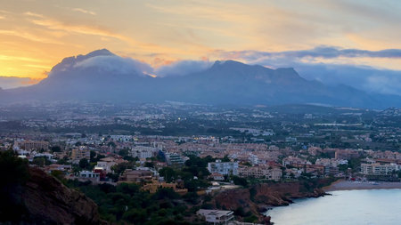 Beautiful coastal view at sunset with mountains, highlighting nature's tranquility and scenic...