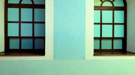 An aesthetically pleasing image showcasing two stunning windows on a vibrant blue wall