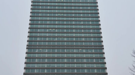This is a sleek, modern building that showcases a striking glass facade along with unique design...