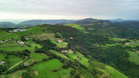 An aerial view shows a picturesque landscape with lush green hills, charming homes, and beautiful...