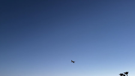 A majestic airplane soars through the bright blue sky, embodying the essence of travel, exploration,...