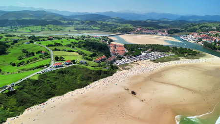 An aerial view showcasing a stunningly beautiful beach landscape that is surrounded by vibrant and...