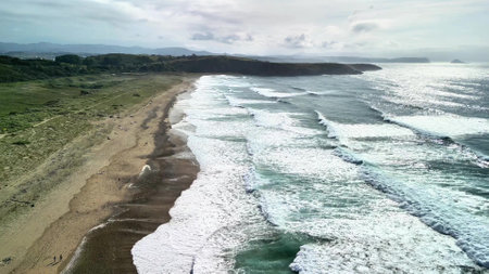 A breathtaking aerial view showcasing a stunning serene beach with crashing waves and vibrant coastal landscapesの写真素材