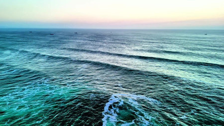 A breathtaking view of the ocean waves in calming colors during sunset, perfect for relaxation visuals.の写真素材