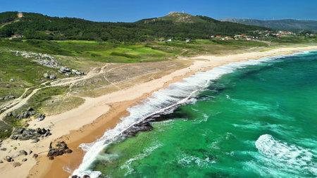 A stunning aerial capture beautifully portrays a tranquil beach adorned with clear turquoise waters and lush landscapesの写真素材