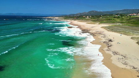 Stunning aerial footage beautifully captures the vibrant turquoise waters and pristine sandy shores of a tranquil beachの写真素材