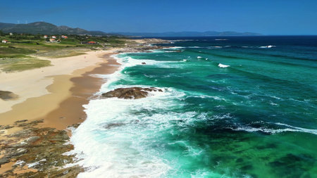 An aerial shot showcasing the beauty of a tranquil beach with clear turquoise waters and gentle waves.の写真素材