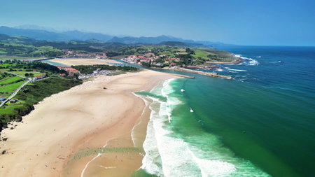 A stunning aerial shot of a tranquil beach with rolling waves and lush greenery, creating an idyllic sceneの写真素材