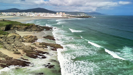 A beautiful coastal view with waves crashing on rocks, enhancing the distant skyline for a perfect...
