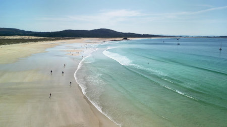 Experience beautiful coastal scenery with a tranquil beach, inviting waters, and lovely sunny weatherの写真素材