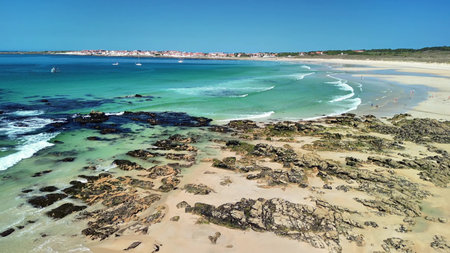 An absolutely breathtaking aerial view of a tranquil beach showcasing inviting clear blue waters and golden sandの写真素材