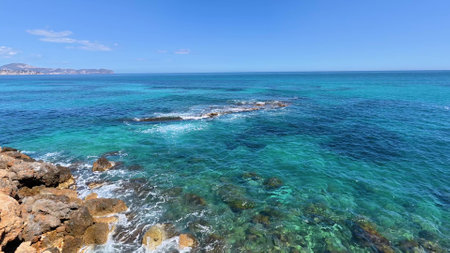 Explore a breathtaking and stunning view of serene, sparkling turquoise waters against dramatic rocky coastlinesの写真素材