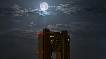 Night view of a modern building with a full moon in the backgroundの写真素材