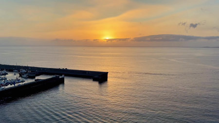 A stunning sunset over the ocean, beautifully captured at a tranquil pier. Perfect for calming imageryの写真素材