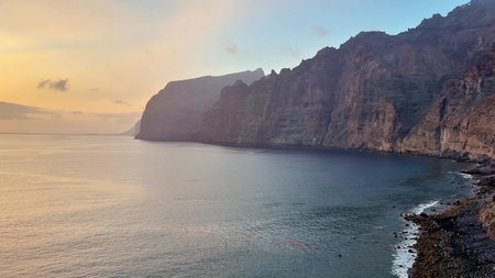 Aerial view of stunning coastal cliffs at sunset, creating a serene landscape that captivates the...