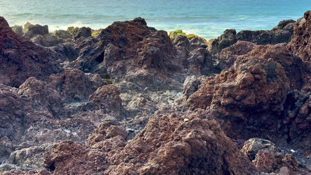 The stunning rocky shoreline features waves powerfully crashing against the rocks, showcasing the...