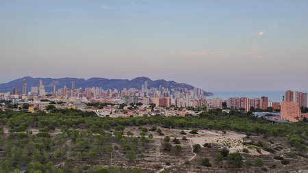 A breathtaking sunset scene unfolds over the city skyline and coastline, beautifully showcasing vibrant architectureの写真素材