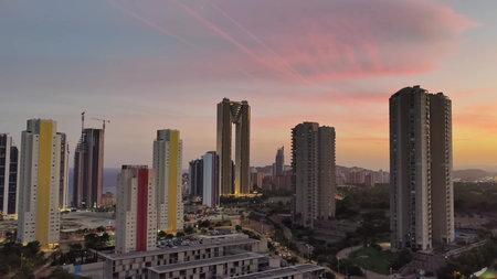 A captivating sunset casts its glow over a vibrant city skyline adorned with stunning modern architectureの写真素材
