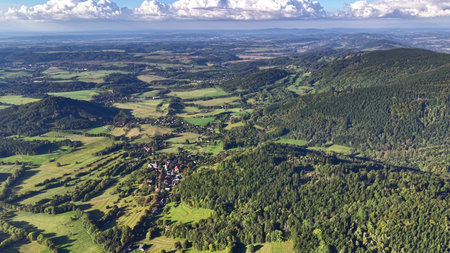 A stunning aerial view showcases an incredibly vibrant green landscape filled with beautiful rolling...